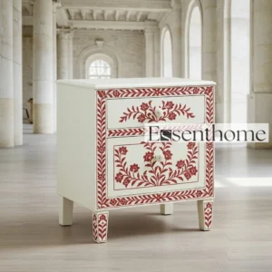 Handmade red and white bone inlay bedside table with floral pattern, two drawers, and decorative bone knobs – Essenthome furniture piece placed in a grand marble interior.